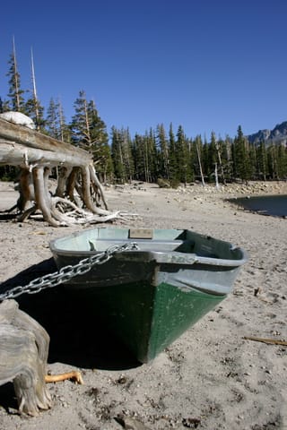 A green rowboat chained on the shore at Horseshoe Lake. 