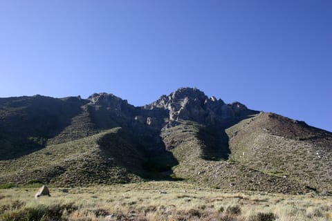 Hills and mountains backed by a blue sky. 