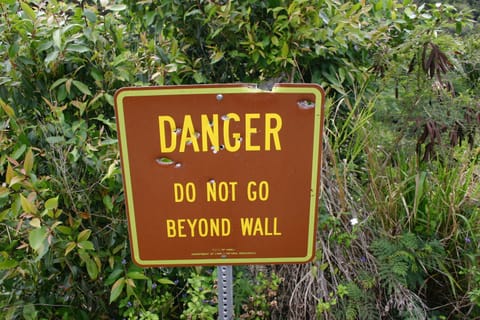 Danger sign near Wailua Falls. Locals use it for target practice. It reads: â€œDanger. Do not go beyond wall. State of Hawaii Department of Land & Natural Resources.â€ 