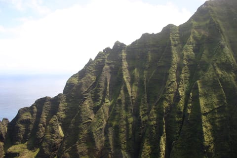 The rugged green cliffs of the NÄ Pali coast, seen from a helicopter. 