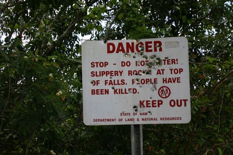 Danger sign near Wailua Falls. Locals use it for target practice. It reads: â€œDanger. Stop - Do not enter! Slippery rocks at top of falls. People have been killed. Keep out. State of Hawaii Department of Land & Natural Resources.â€ 