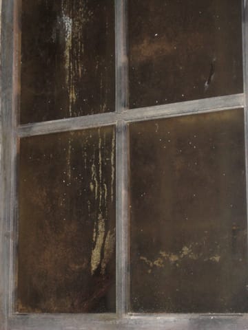 Closeup on an old dirty brown window. 
